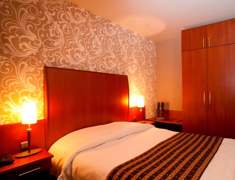 - une chambre avec un grand lit et deux lampes dans l'établissement Hotel De Notelaer, à Bornem