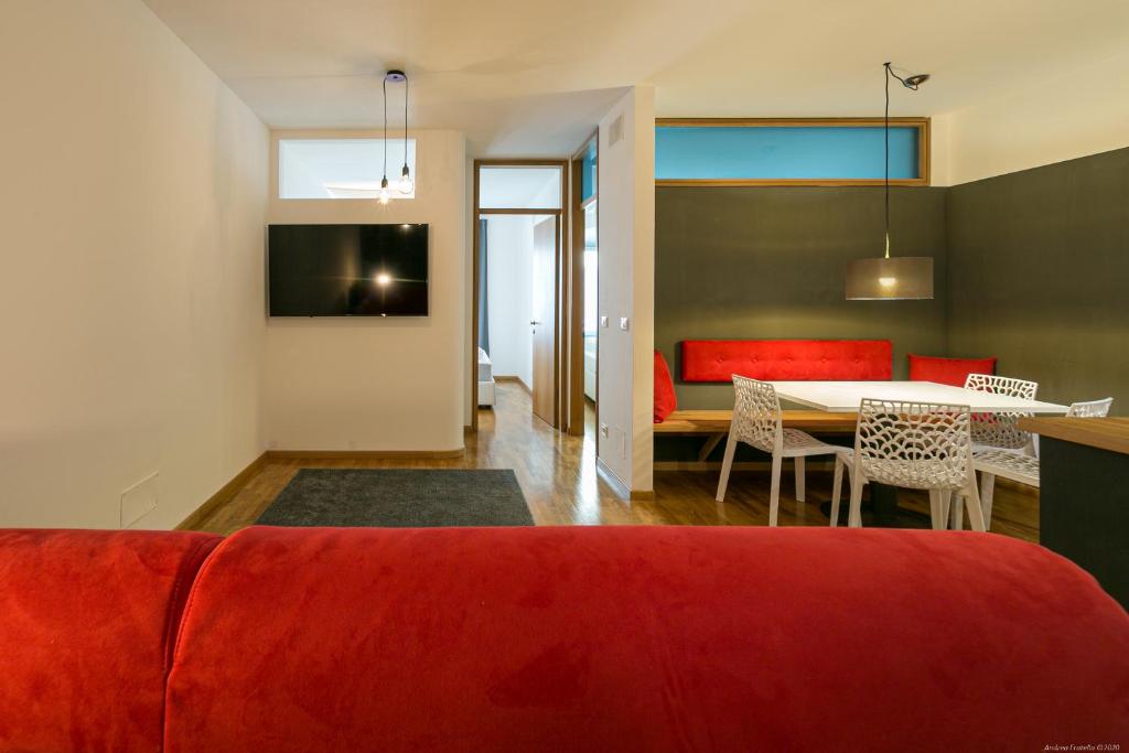 salon z czerwoną kanapą i stołem w obiekcie Laubenapartment w Meranie