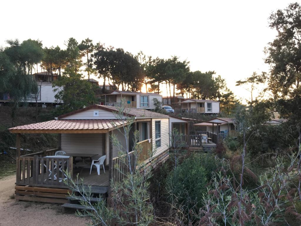 una casa al lado de una colina con árboles en Camping TIKITI en Propriano