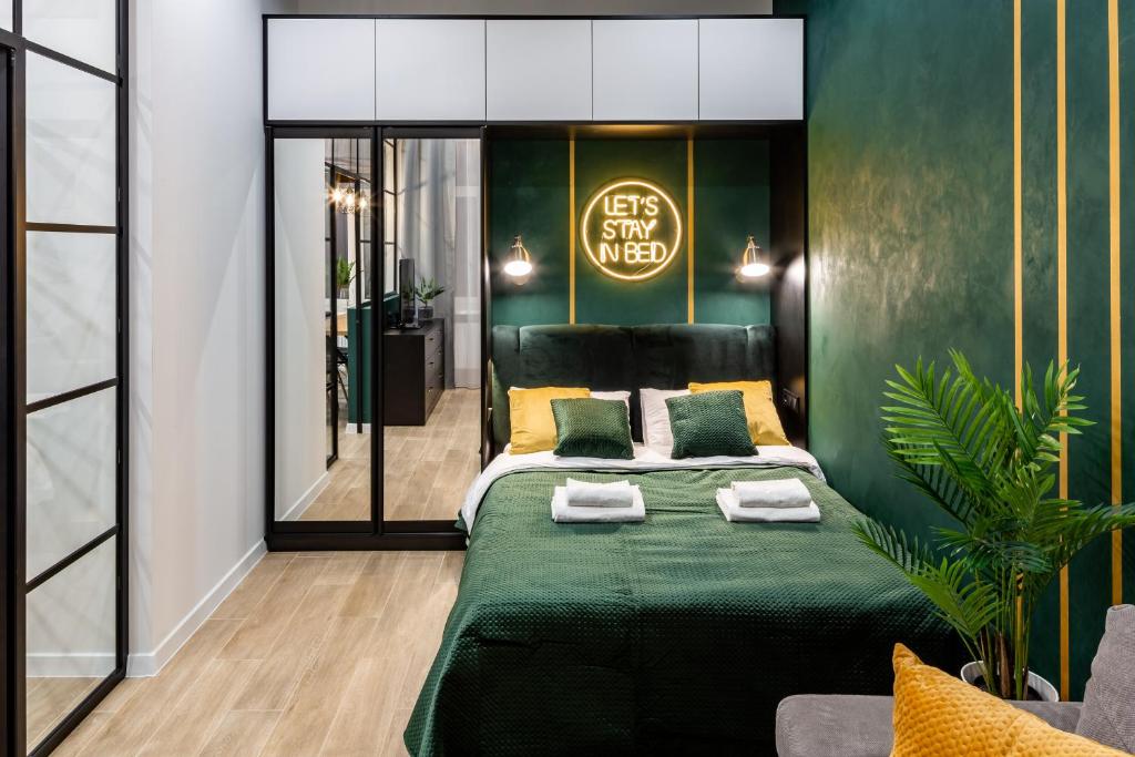ein Schlafzimmer mit einem grünen Bett und einer grünen Wand in der Unterkunft Emerald Lux Apartment. LiveInLviv in Lwiw