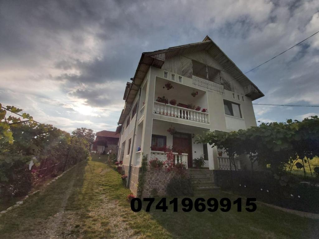 un edificio blanco con un balcón en el lateral. en Pensiunea Angelica, en Baia de Fier