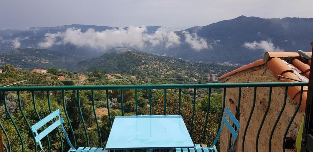 a blue table and chairs on a balcony with a mountain at La cachette in Berre-les Alpes
