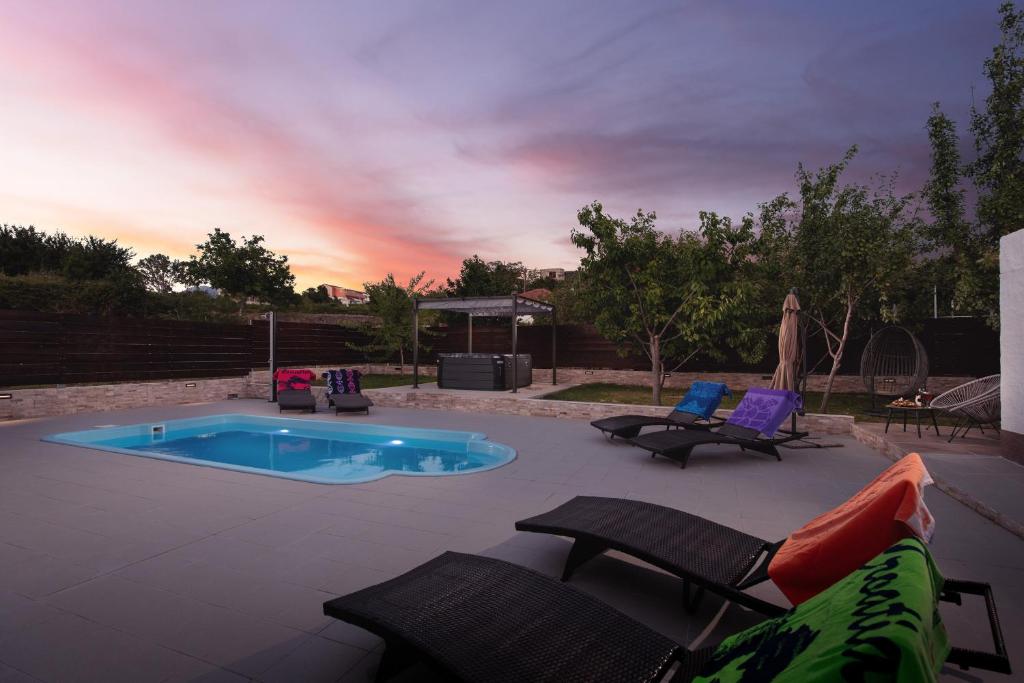 a patio with chairs and a small swimming pool at Villa Little Heaven in Split
