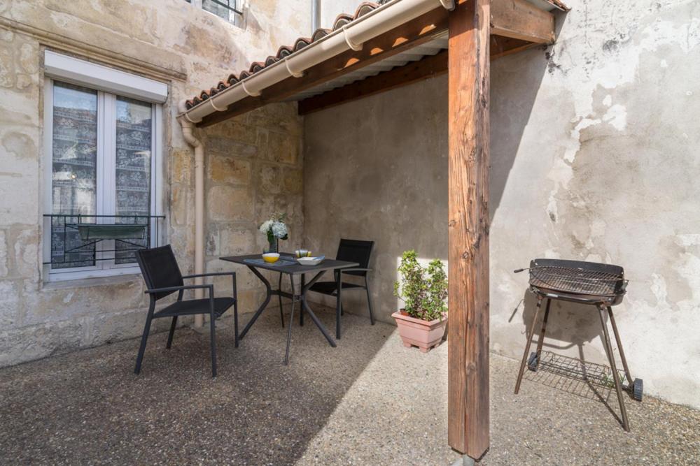 un patio avec une table, des chaises et un barbecue dans l'établissement île d’Aix, à Rochefort