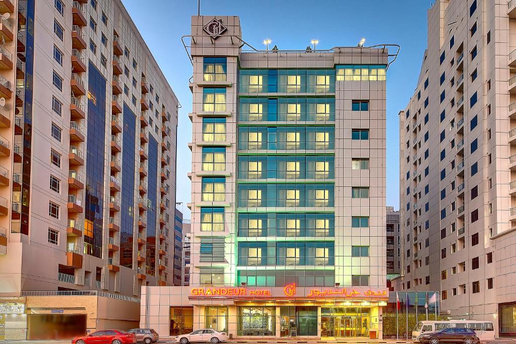 een hoog gebouw met een klok erop bij Grandeur Hotel Al Barsha in Dubai