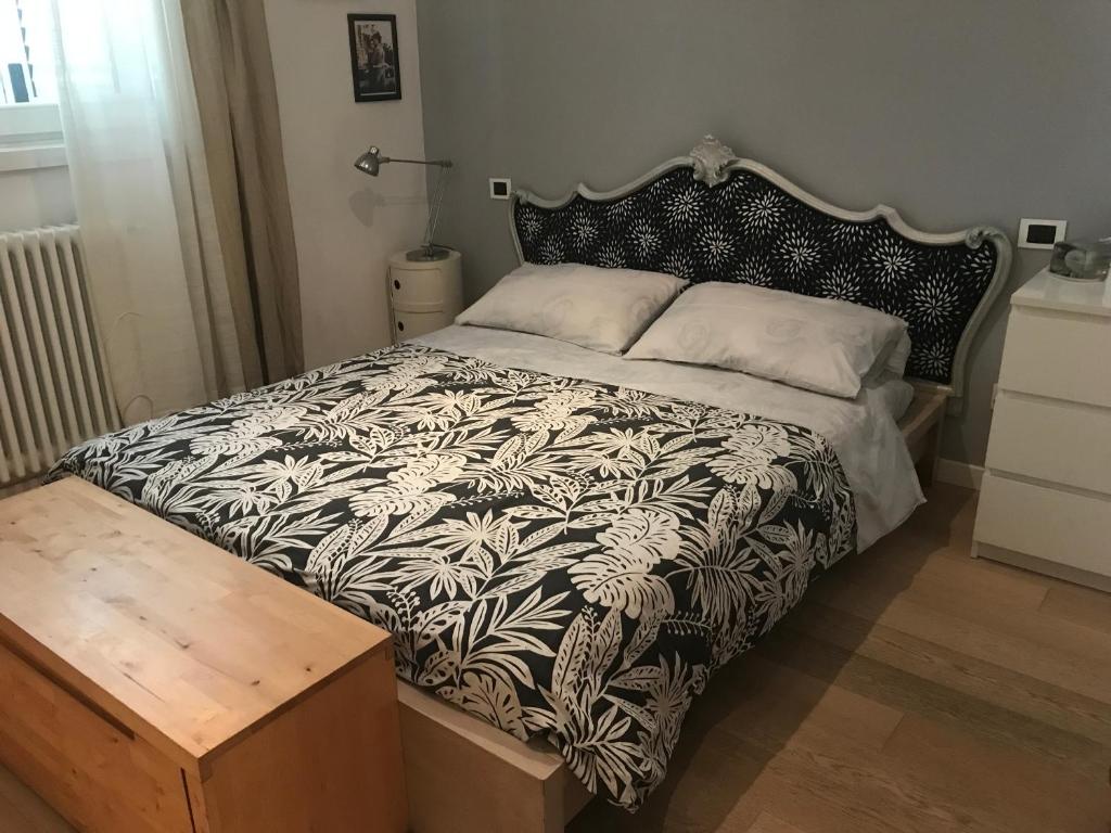 a bedroom with a bed with a black and white comforter at camera con bagno privato e parcheggio in Lucca