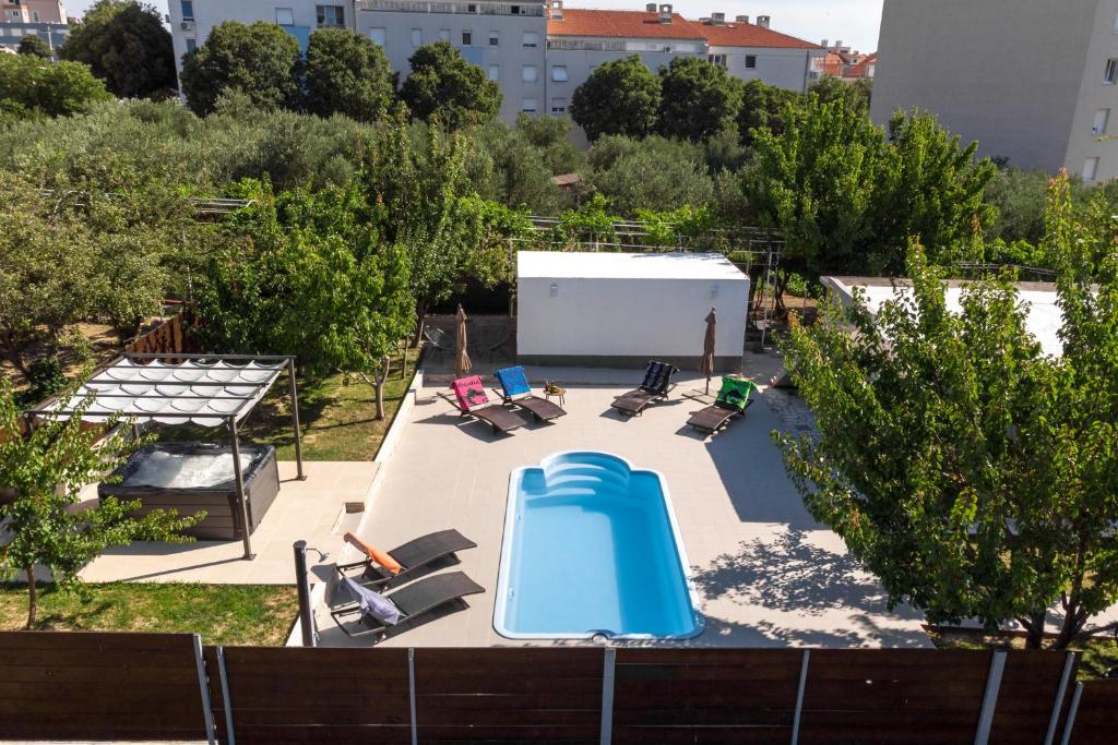 Blick auf einen Pool mit Stühlen und einer Wasserrutsche in der Unterkunft Villa Little Heaven in Split