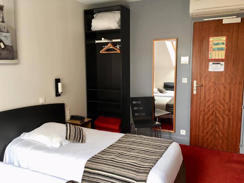 Postel nebo postele na pokoji v ubytování Hôtel Le Bayeux