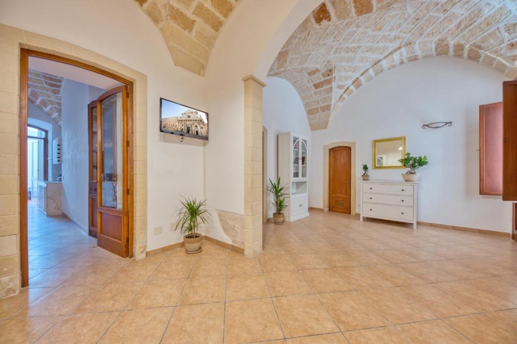 una grande camera con un arco in pietra e un corridoio di Corte Anibaldi Apartment a Lecce