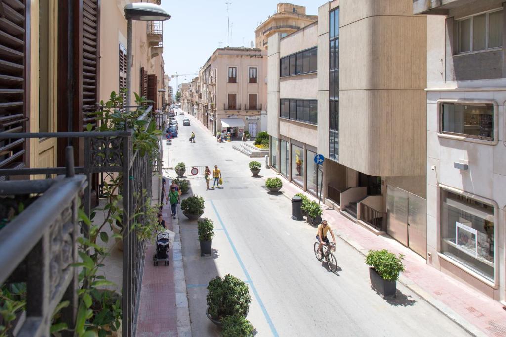 vista su una strada cittadina con persone che pedalano in bicicletta di Dimora La Commare a Marsala