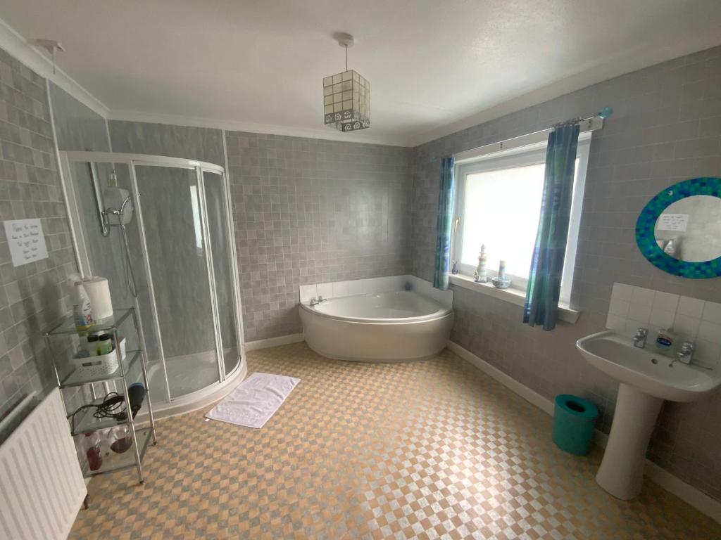 un bagno con vasca e lavandino di Dunrigh Guest House a Oban