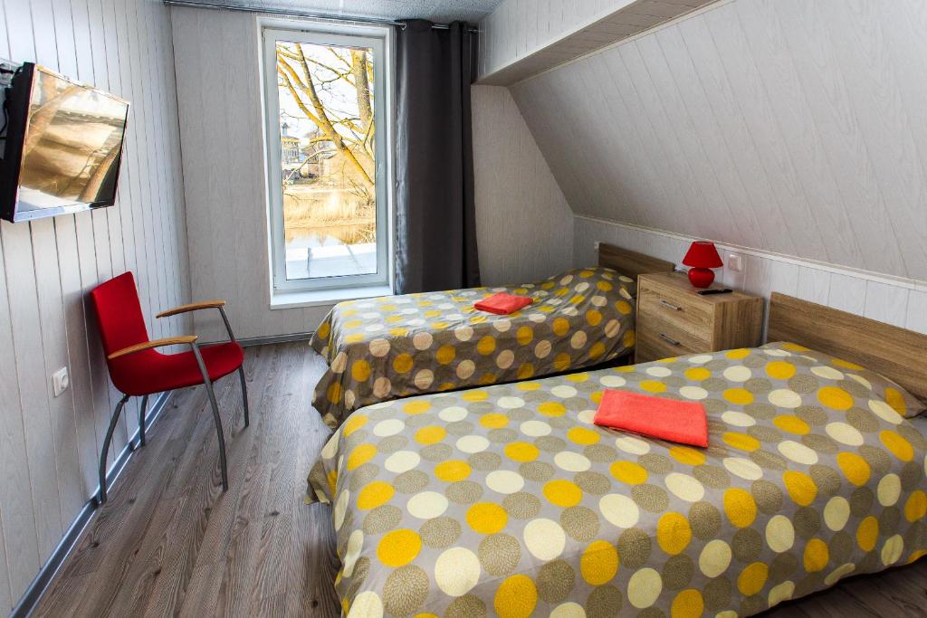 a attic room with two beds and a window at Vetesina in Pärnu
