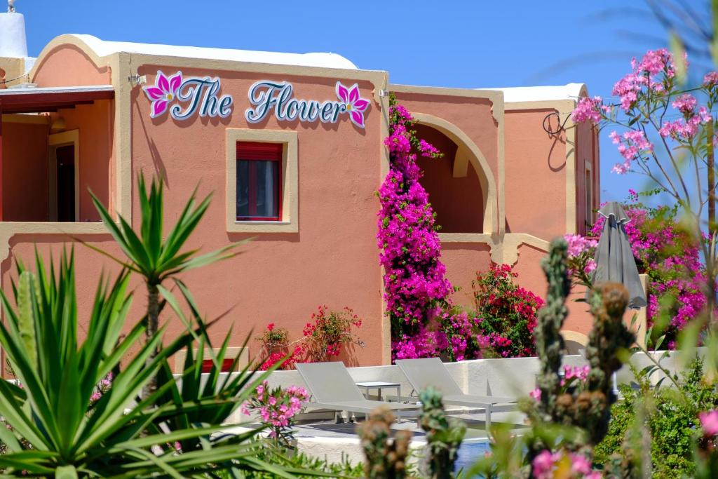 a pink building with a sign that reads the flowers at Pension The Flower in Oia