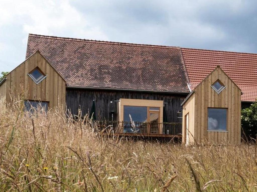 a wooden house sitting on top of a field at Tiny Houses der Dorfscheune in Bieselberg
