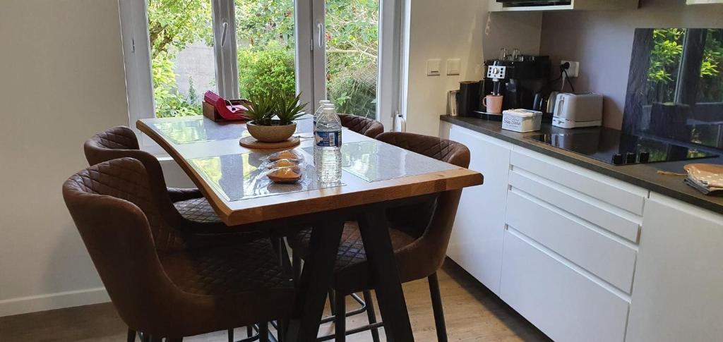 a kitchen with a table and chairs in a kitchen at Concept Appart'Hôtel Lannion - Côte de Granit Rose in Lannion