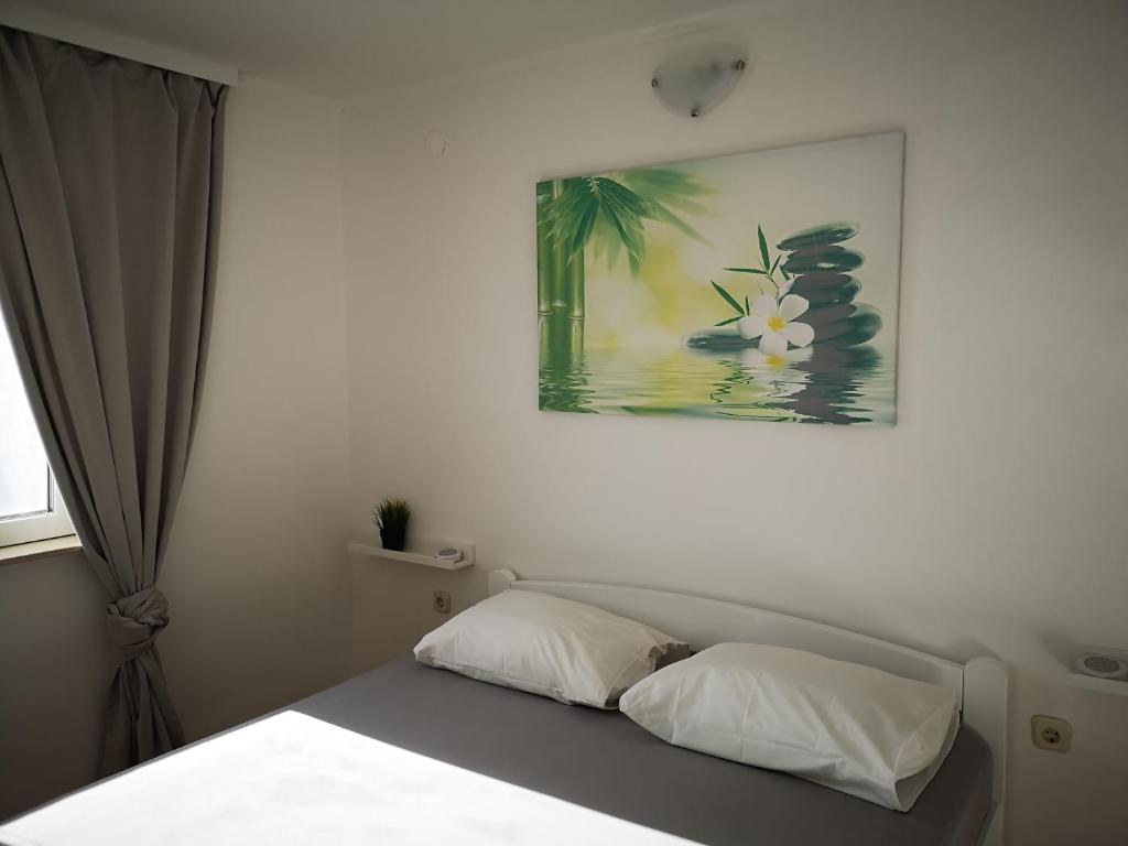 a bedroom with a bed and a painting on the wall at Chillout Apartments with Pool Patricia in Fažana