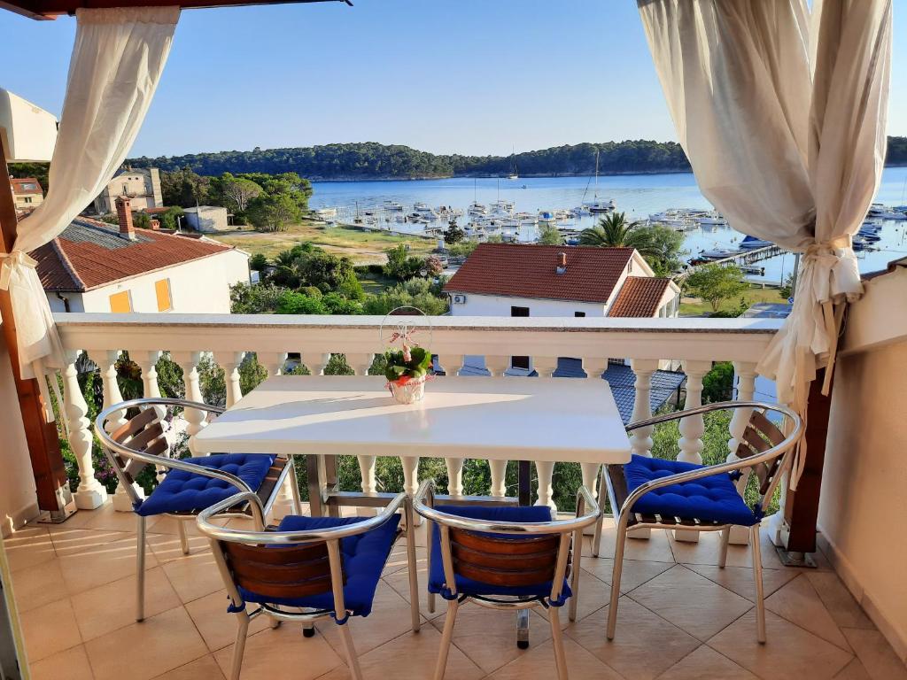 a balcony with a table and chairs and a view of the water at Apartman Martina in Rab