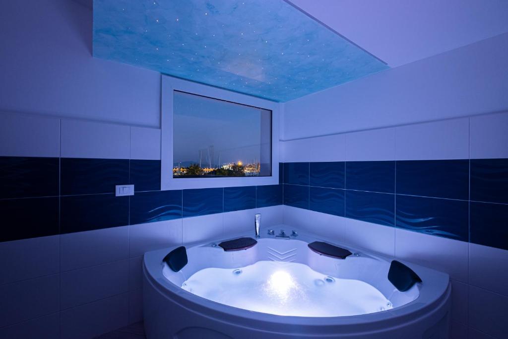 eine Badewanne im Bad mit blauer Beleuchtung in der Unterkunft Bali - BeDreams in Gaeta