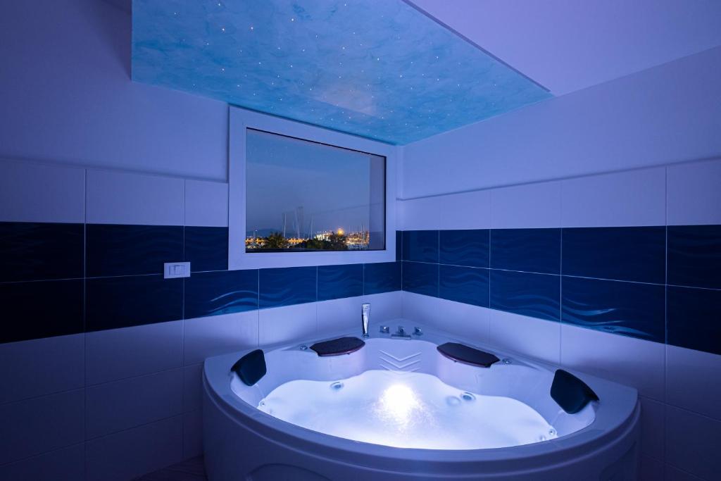 a bath tub in a bathroom with a blue lighting at Bali - BeDreams in Gaeta