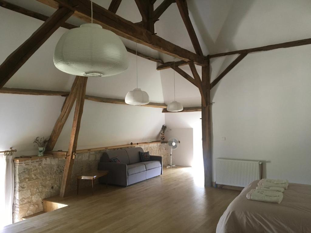 a bedroom with a bed and a couch in a room at Chambre d'Hotes Cugnac in Sainte-Sabine