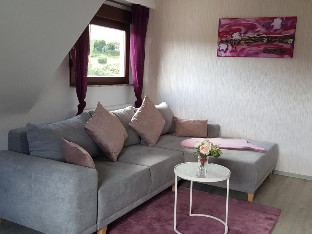 uma sala de estar com um sofá e uma mesa em Ferienwohnung Pusteblume em Forbach