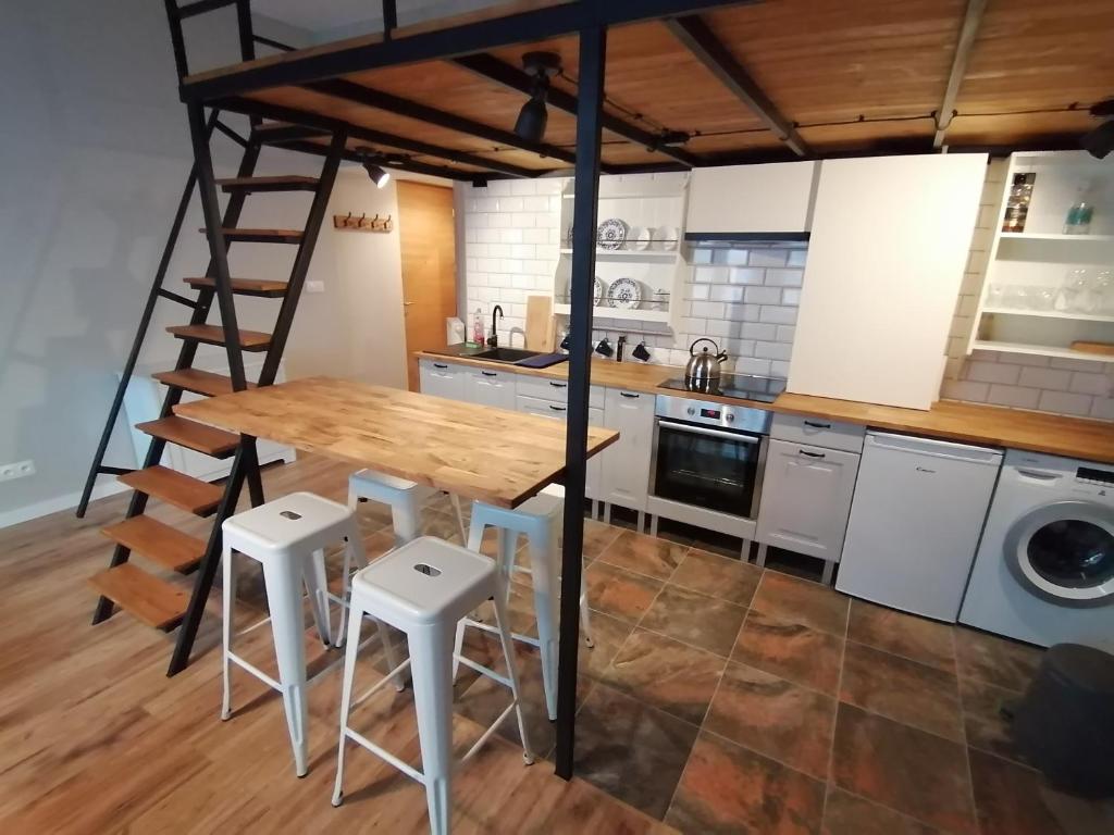 a kitchen with a wooden table and some stools at Studio Krakow old town apartment in Krakow