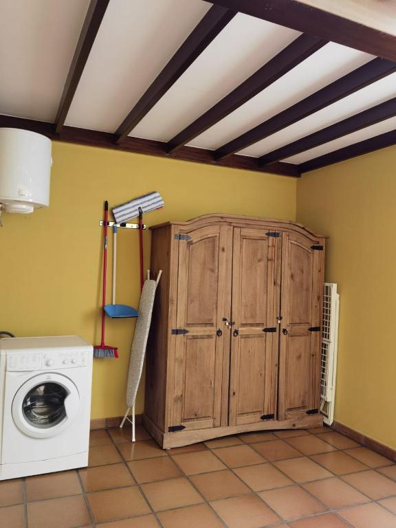 a laundry room with a washing machine and a wooden cabinet at Nautilus I: Casa con terraza y vistas al mar in La Caleta