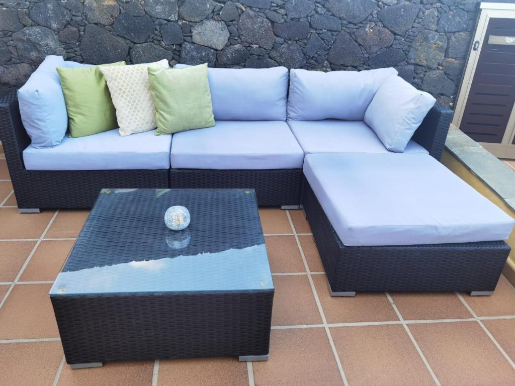a couch and a coffee table on a patio at Nautilus I: Casa con terraza y vistas al mar in La Caleta