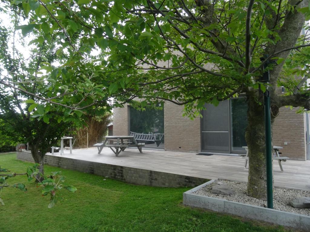 einen Park mit einer Picknickbank und einem Gebäude in der Unterkunft La Pauline in Veurne
