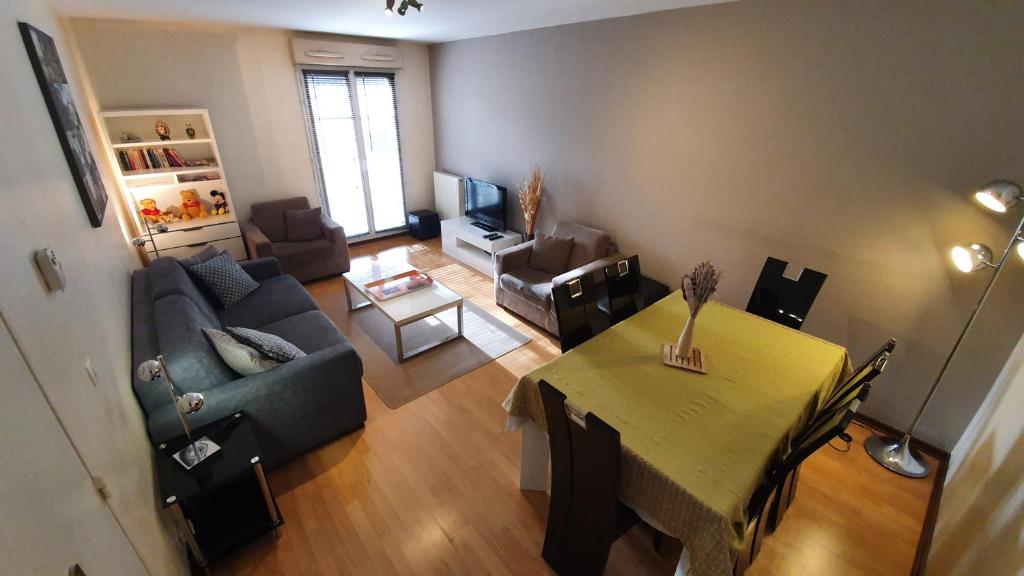 شقة إن تشيسي فاري نيير ديزني لاند في شيسي: غرفة معيشة مع طاولة وأريكة وغرفة معيشة مع طاولة