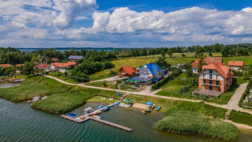 eine Luftansicht eines Hauses auf einer Insel im Wasser in der Unterkunft Niebieska Tawerna in Angerburg