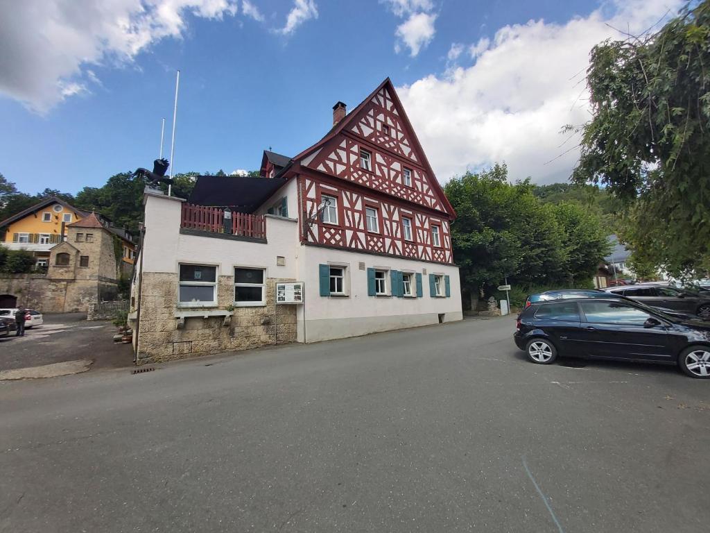 un edificio con un coche aparcado delante de él en Schwarze Adler, en Streitberg