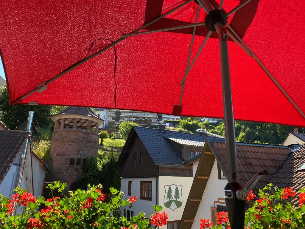 ein roter Regenschirm vor einigen Häusern in der Unterkunft Pension Thilo in Bad Wildbad