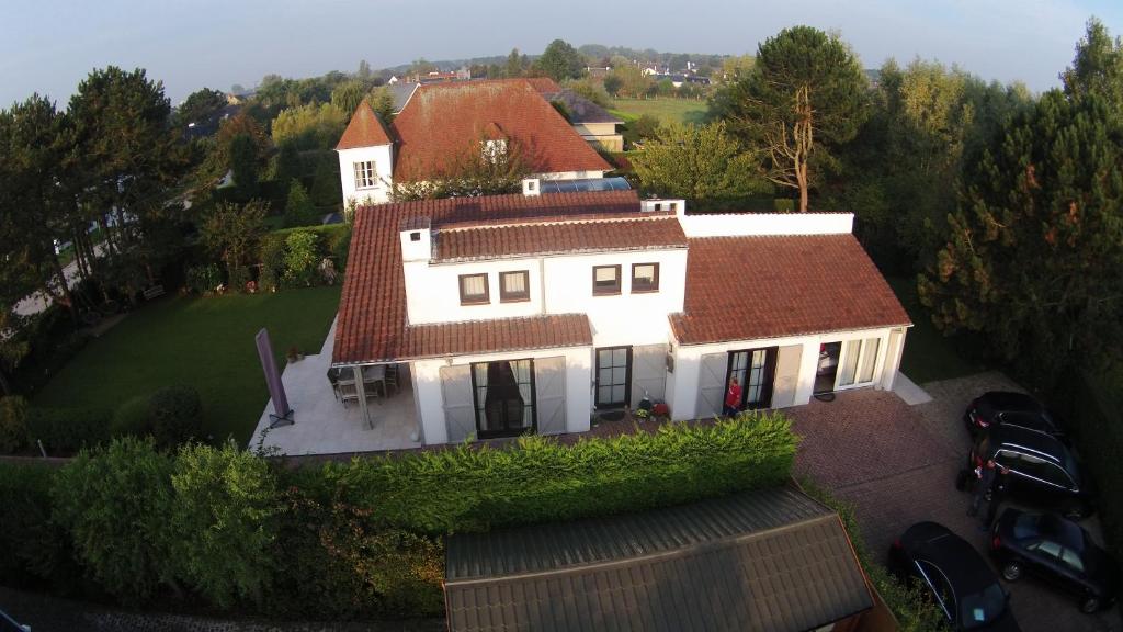 ein großes weißes Haus mit rotem Dach in der Unterkunft B&B Yaca in De Haan