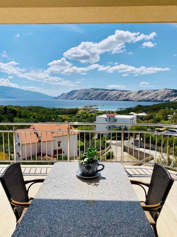 a table on a balcony with a view of the water at Mare E Sabbia in Lopar