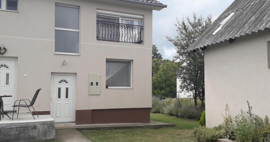 une maison blanche avec une porte blanche et une table dans l'établissement Studio apartmani Sofija, à Vrdnik