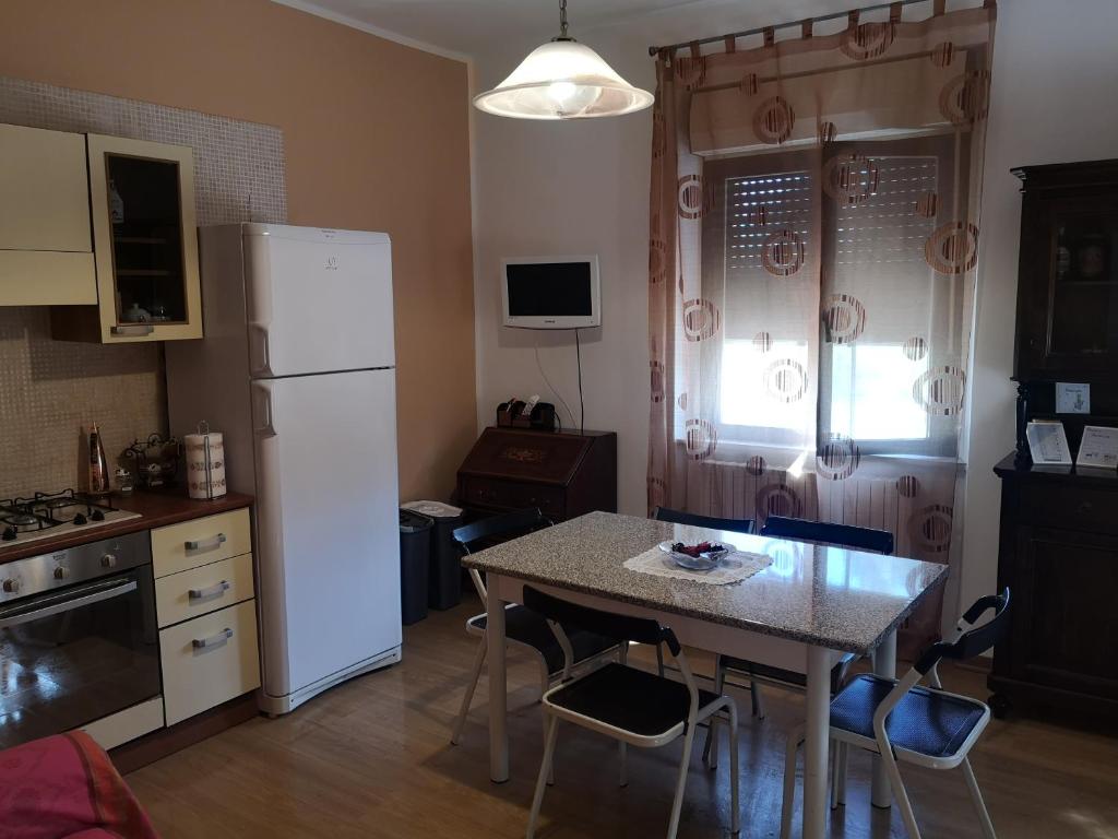 kuchnia ze stołem i białą lodówką w obiekcie Da Nonna Stella w mieście Miglianico