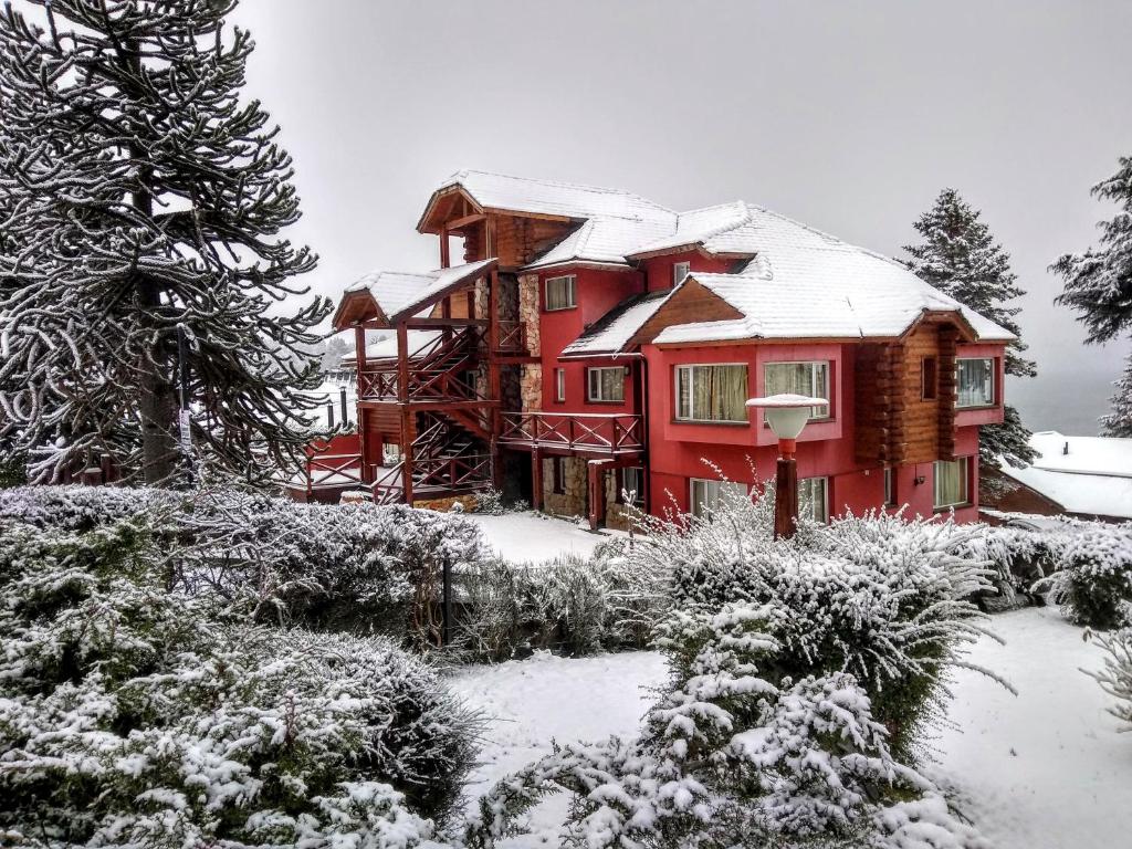 Una gran casa roja con nieve. en Solar de las Araucarias en San Carlos de Bariloche