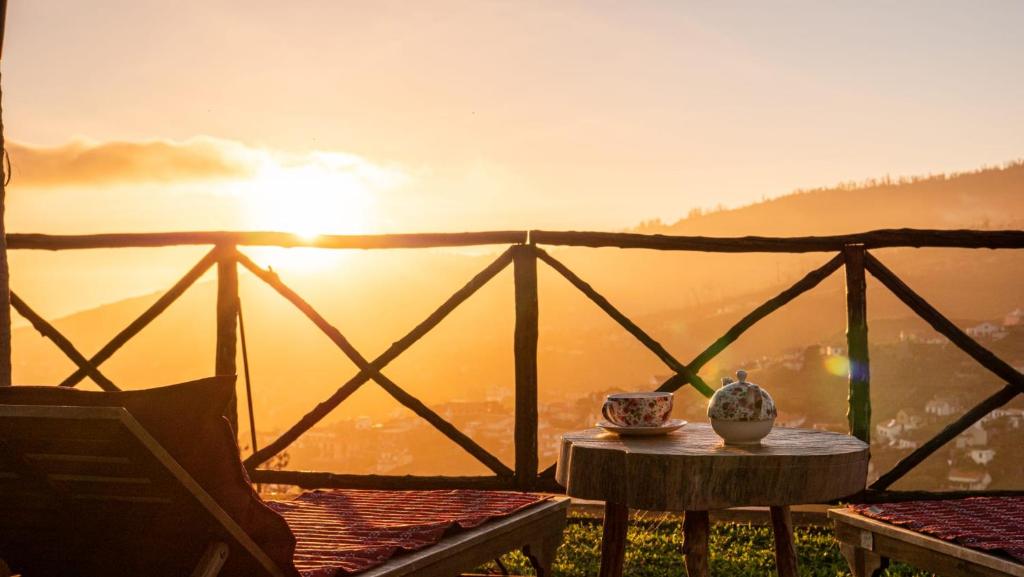 a table with a vase sitting on top of a balcony at Casa dos Avos in Calheta