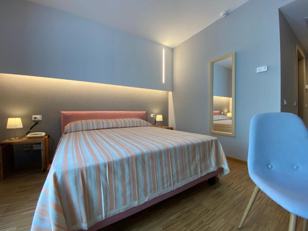 um quarto com uma cama, uma cadeira e um espelho em Delta Park em Porto Viro