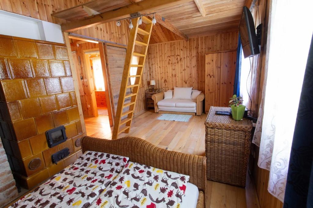 ein Schlafzimmer mit einem Bett und einer Leiter in einem Zimmer in der Unterkunft Barna Faház in Tarnaszentmária