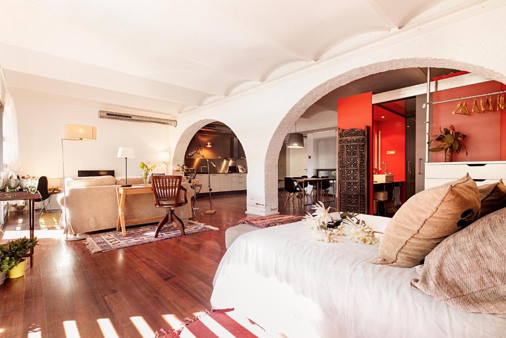 uma sala de estar com uma cama branca e uma cozinha em BEACH LOFT TERRACE BCN em Barcelona
