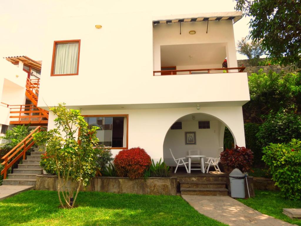 a house with a balcony and a yard at Hotel Bracamonte in Huanchaco