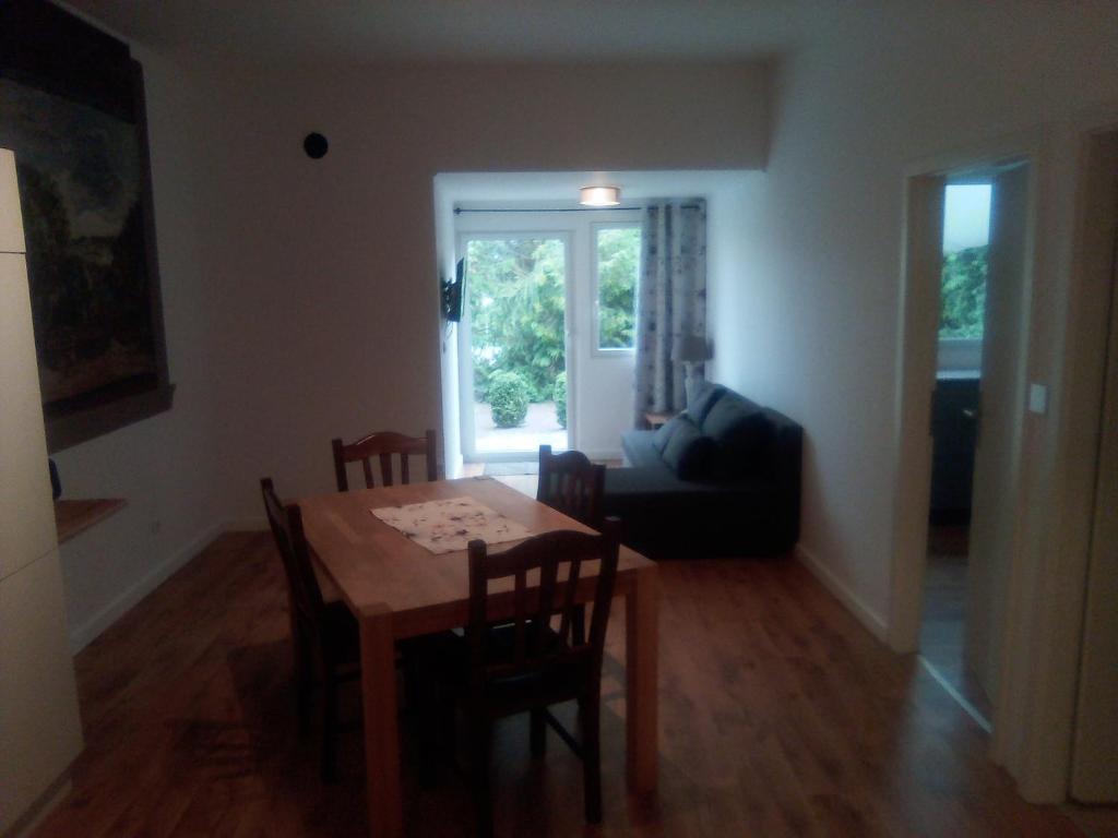 - une salle à manger avec une table, des chaises et un canapé dans l'établissement Ferienwohnung Linde Otzenhausen, à Nonnweiler