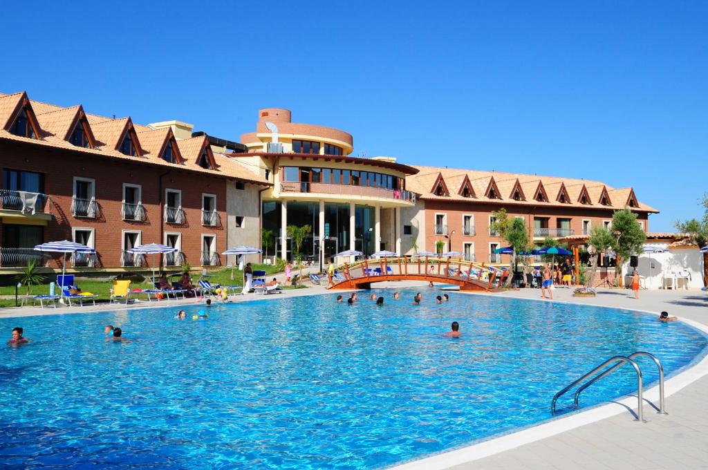 a large swimming pool in a resort with people in it at Corte dei Greci Resort & Spa in Cariati