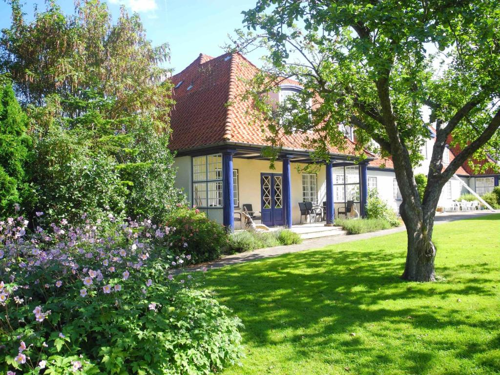une maison avec un arbre dans la cour dans l'établissement Inspiration Center Denmark, Guesthouse, à Maribo