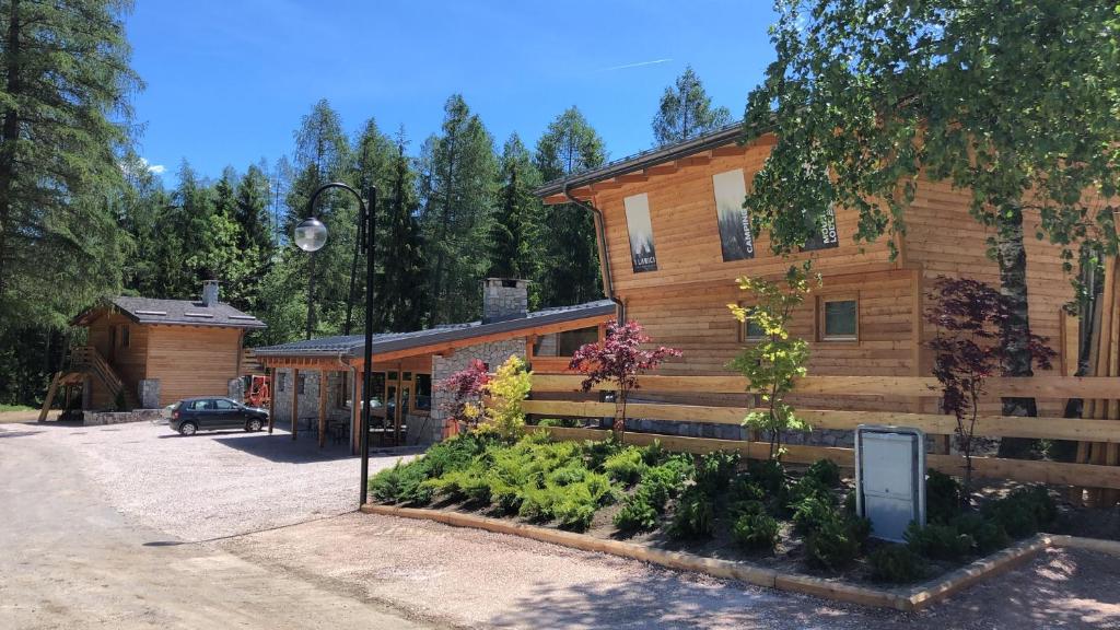 una casa de madera con un jardín delante de ella en I Larici Camping Lodge, en Ossana