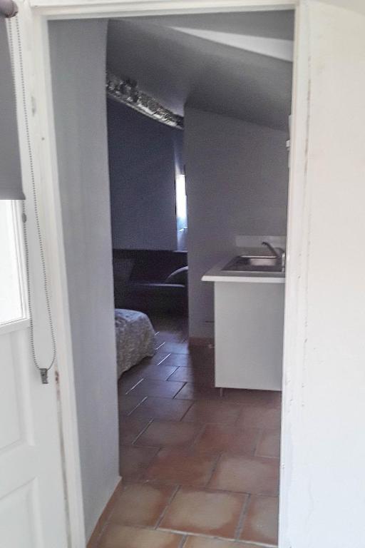 un couloir menant à une chambre avec une cuisine dans l'établissement Studio entre Cévennes et Camargue, à Montfrin
