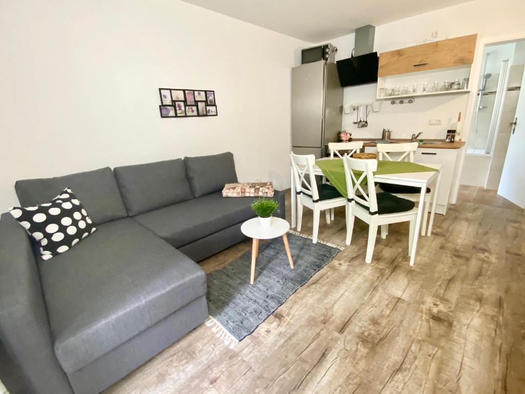 ein Wohnzimmer mit einem Sofa und einem Tisch sowie eine Küche in der Unterkunft FeWo Rehblick in Schönau am Königssee