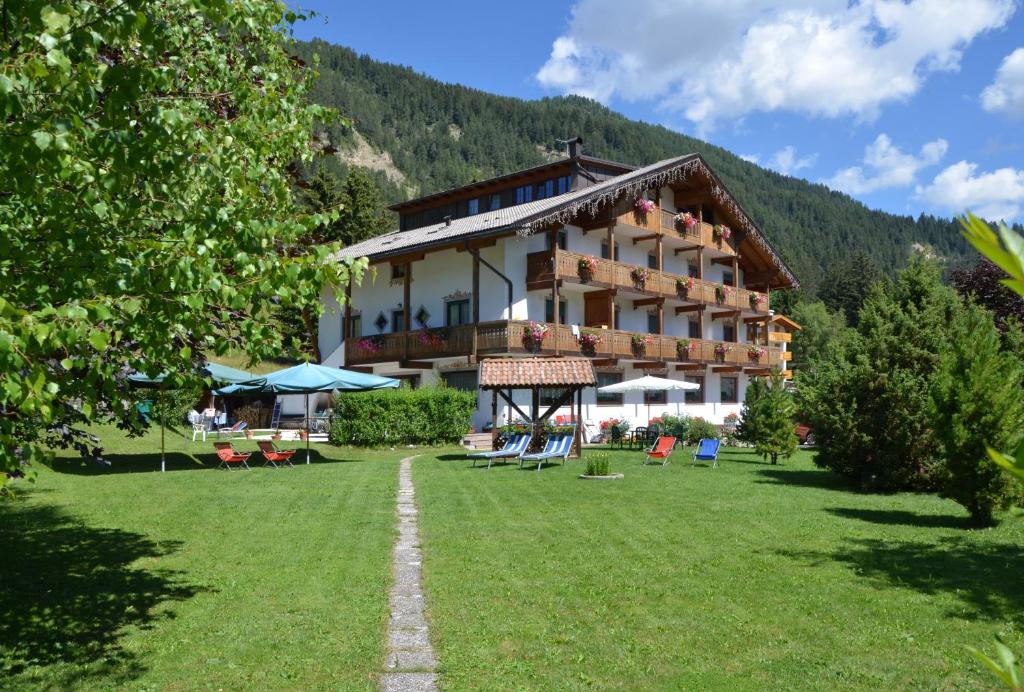a large building with a lawn in front of it at Villa Gemmy in Pozza di Fassa
